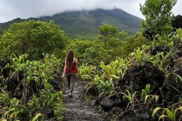 woman from behind walking in jungle landscape of costa rica