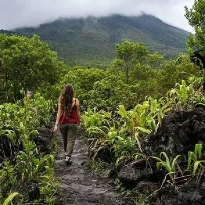 woman from behind walking in jungle landscape of costa rica