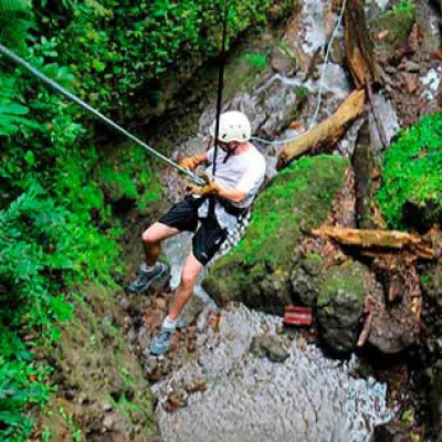 man being lowered while canyoning in the jungle