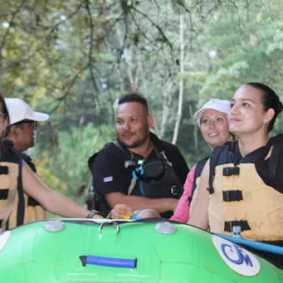 small group of people standing by green raft