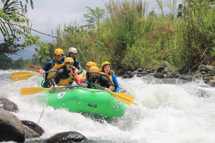 a group of people riding on the back of a boat in the water