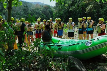 group of people in a jungle standing by raft