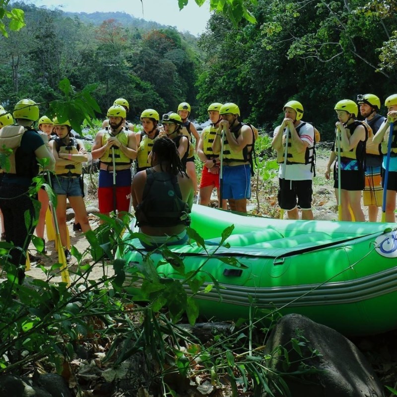 group of people in a jungle standing by raft