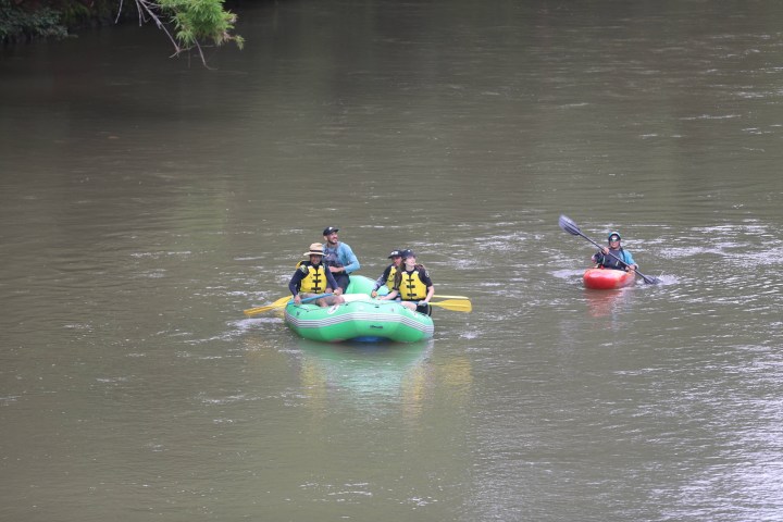 a group of people riding on the back of a boat in the water